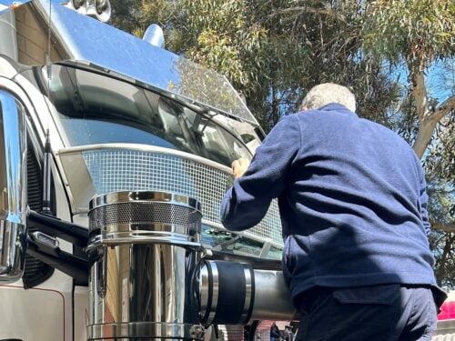 A staff member fitting a Kenworth T610 with a Silver Windscreen Stoneguard